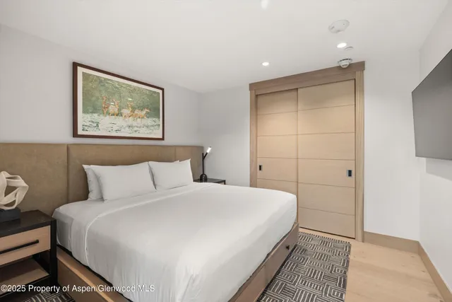 a bedroom with a bed and a painting on the wall