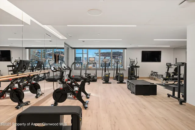 a large white kitchen with a large window and stainless steel appliances