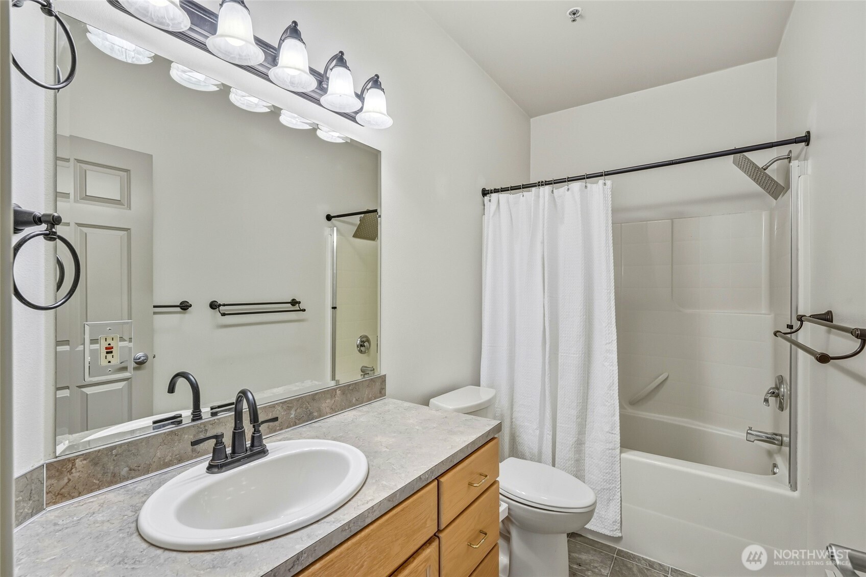 3501 Colby Avenue, Unit 311 Everett, WA 98201 - Photo 17 of 28 a bathroom with a sink toilet a mirror and shower