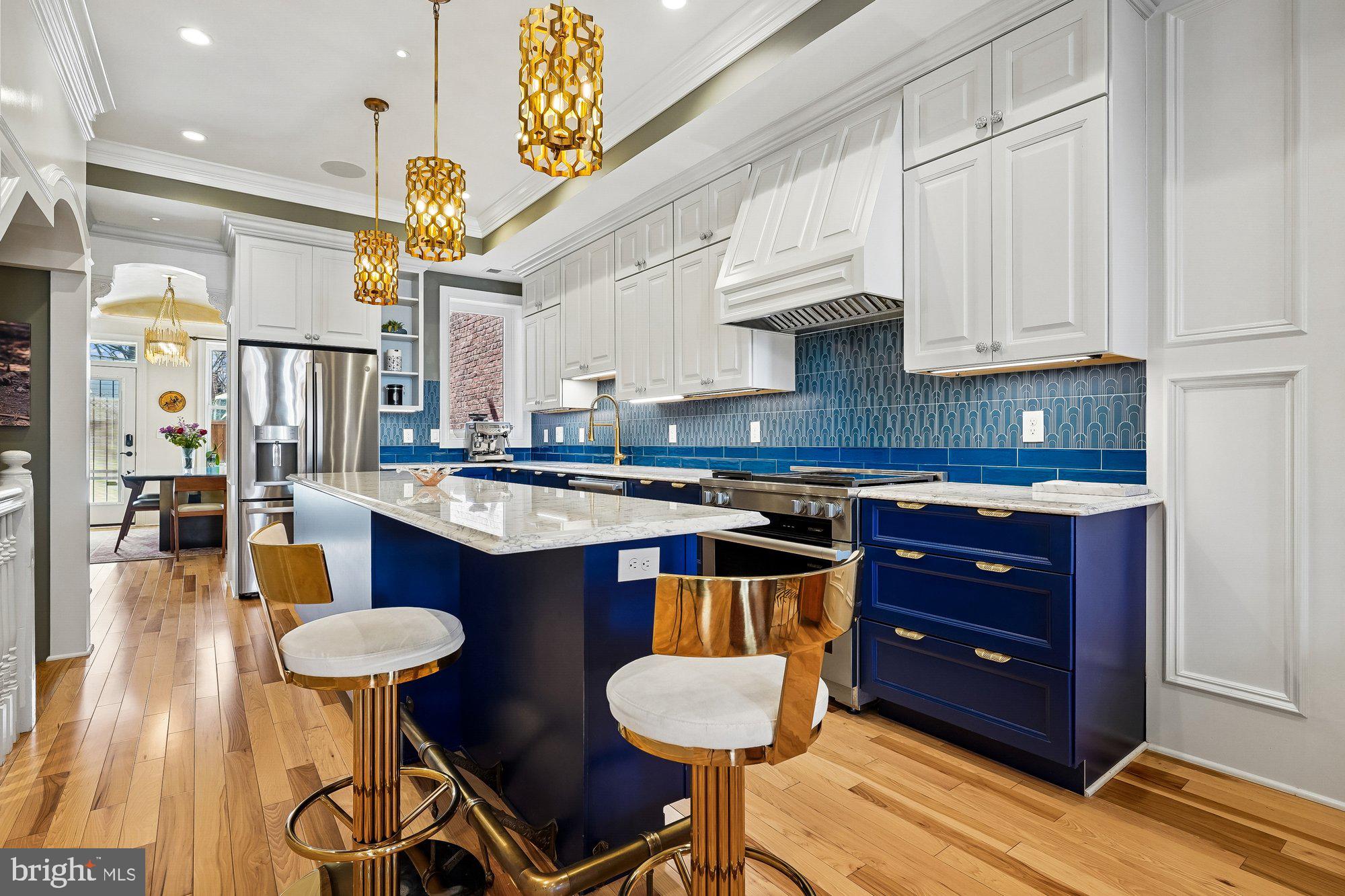 909 C Street Northeast Washington, DC 20002 - Photo 11 of 43 a kitchen with stainless steel appliances granite countertop a sink a stove and chairs with wooden floor