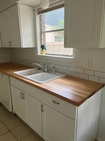 a sink with cabinets and window