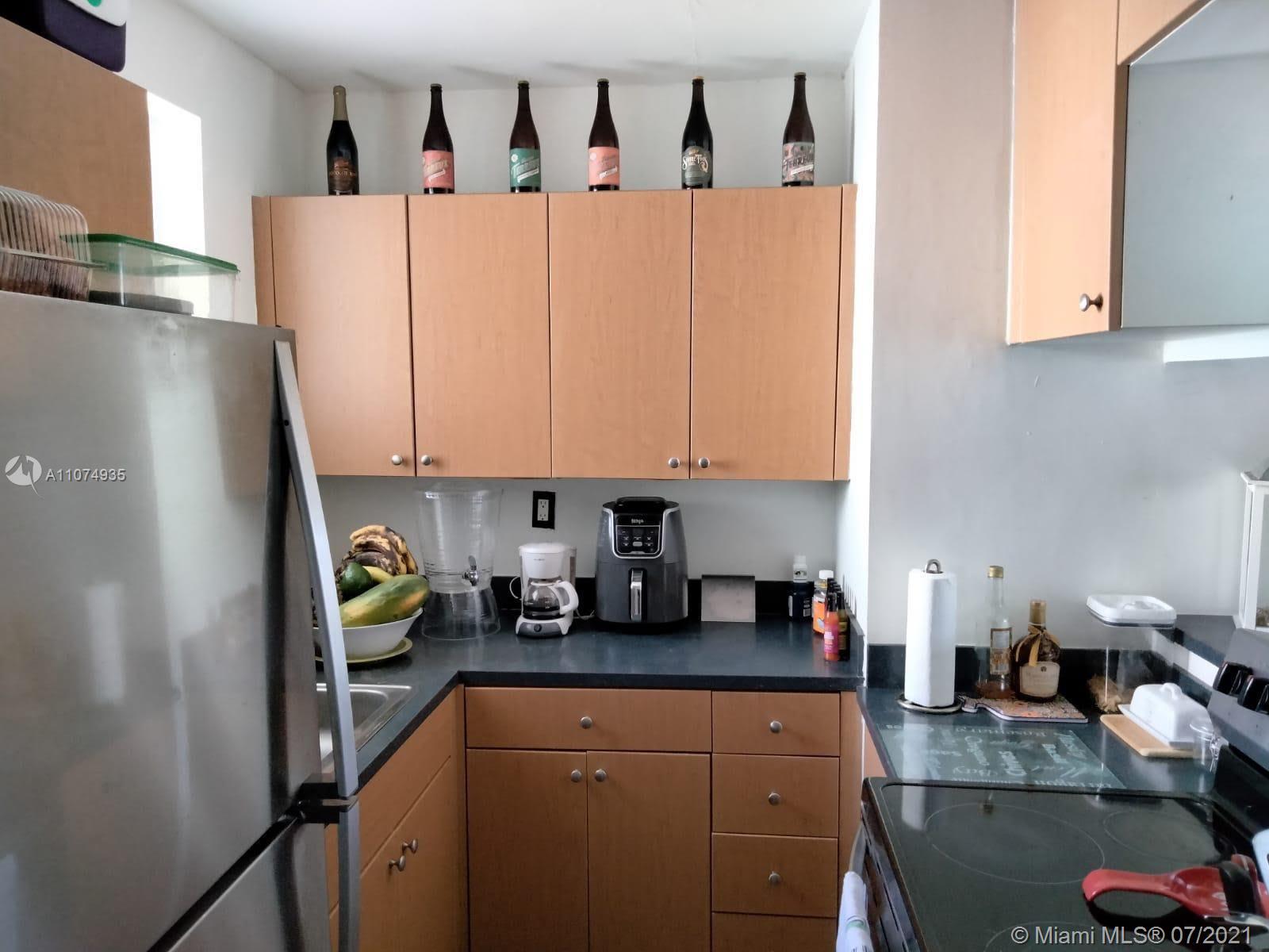 665 Northeast 83rd Terrace, Unit 314 Miami, FL 33138 - Photo 3 of 10 a kitchen with stainless steel appliances a white refrigerator a sink a stove and white cabinets
