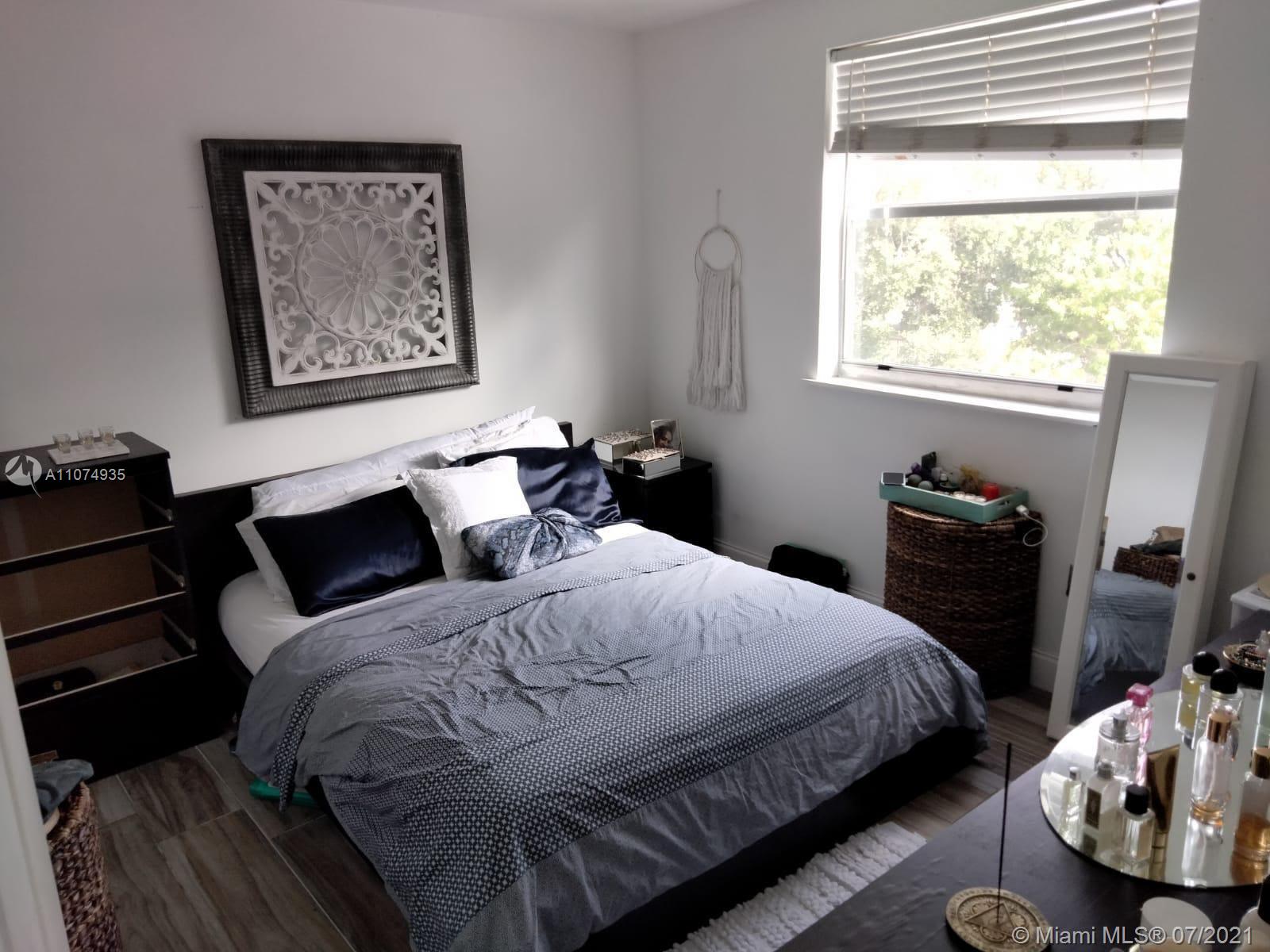 665 Northeast 83rd Terrace, Unit 314 Miami, FL 33138 - Photo 9 of 10 a bedroom with a bed and wooden floor