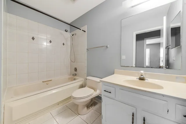 a bathroom with a bathtub shower sink vanity and toilet