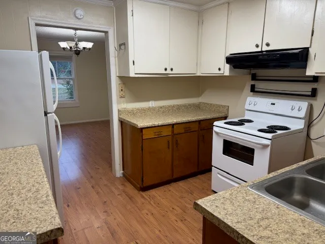 a kitchen with granite countertop a stove and a wooden floors