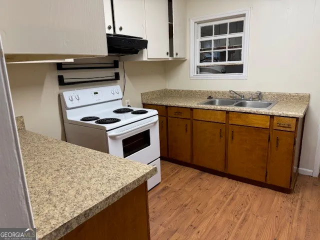 a kitchen with granite countertop wooden cabinets and a stove top oven