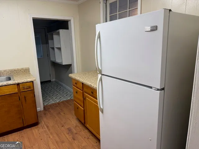 a kitchen with a refrigerator and a stove top oven