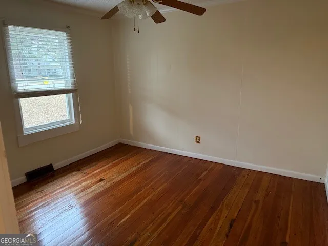 a view of a room with wooden floor and windows