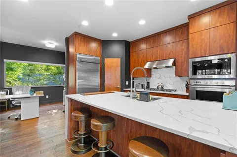 a kitchen with stainless steel appliances granite countertop a sink a stove and a refrigerator