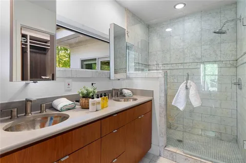 a bedroom with a bed a flat screen tv and a large window