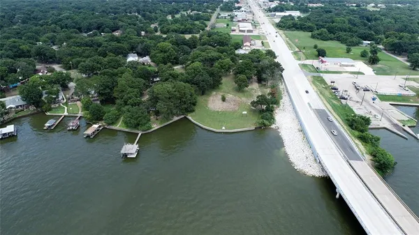 an aerial view of a house with a yard and lake view