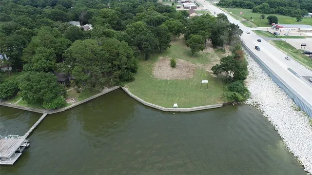 an aerial view of a house with a yard and lake