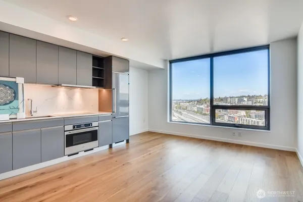 a kitchen with granite countertop wooden floors and stainless steel appliances
