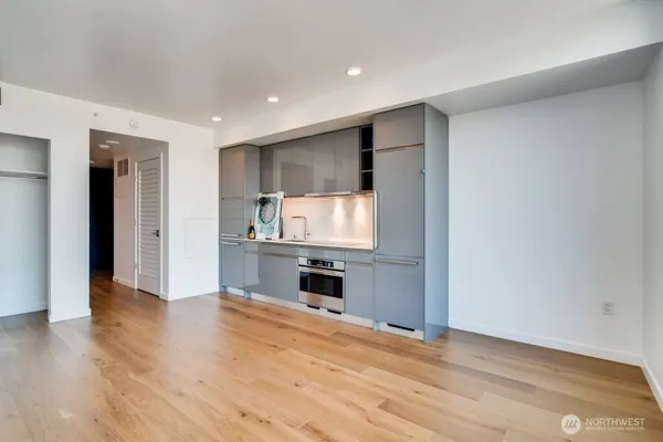 a room with stainless steel appliances wooden floor and view living room