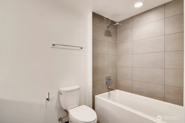 a white toilet sitting next to a bathtub