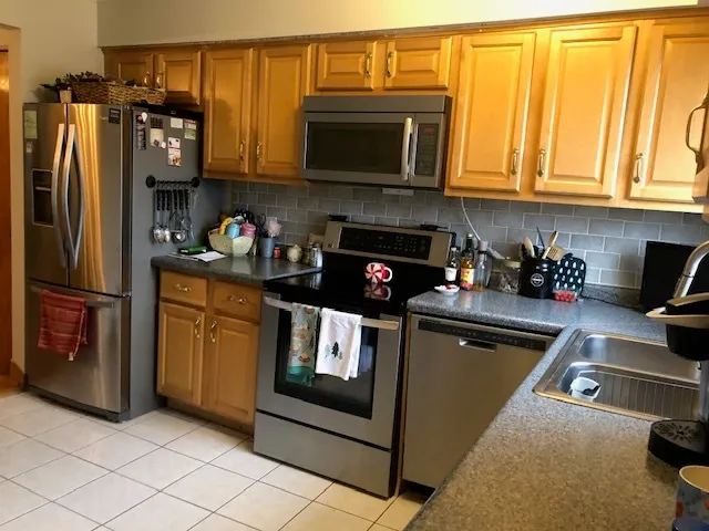 a kitchen with stainless steel appliances granite countertop a refrigerator stove and microwave