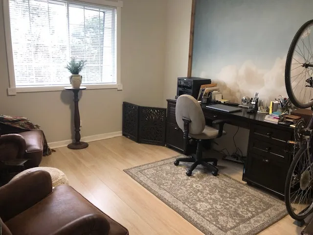 a view of a workspace with furniture and a window