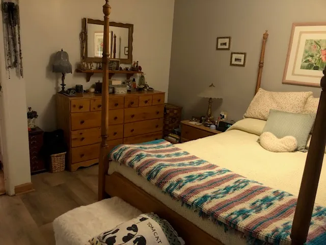 a bedroom with a bed and wooden floor