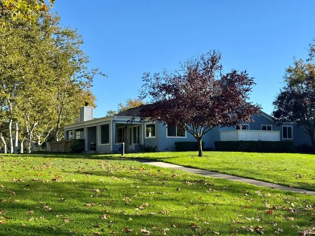 a house view with swimming pool in front of it