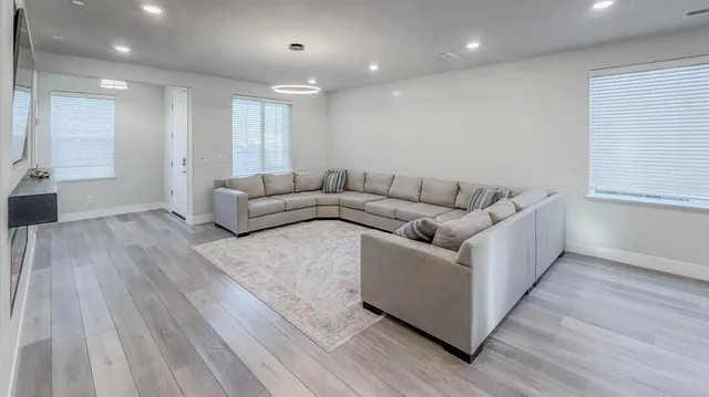 a living room with furniture and a wooden floor