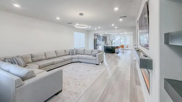 a living room with furniture and a wooden floor
