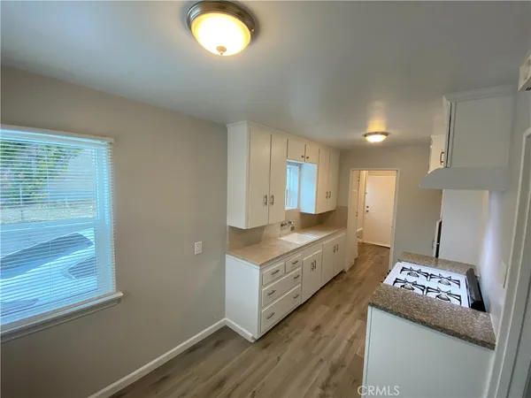 a large kitchen with cabinets wooden floor and stainless steel appliances