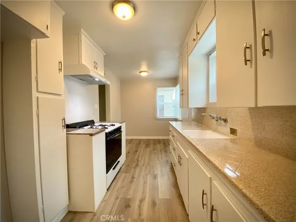 a kitchen with stainless steel appliances granite countertop a lot of counter space and wooden floors