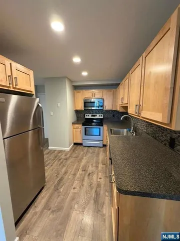 a kitchen with granite countertop a refrigerator and a sink