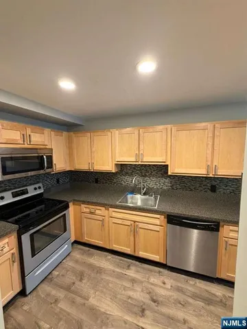 a kitchen with stainless steel appliances granite countertop a stove a sink and a microwave
