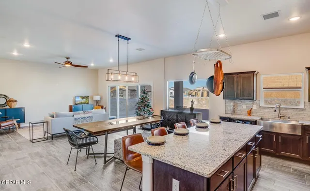 a kitchen with granite countertop a table and chairs in it