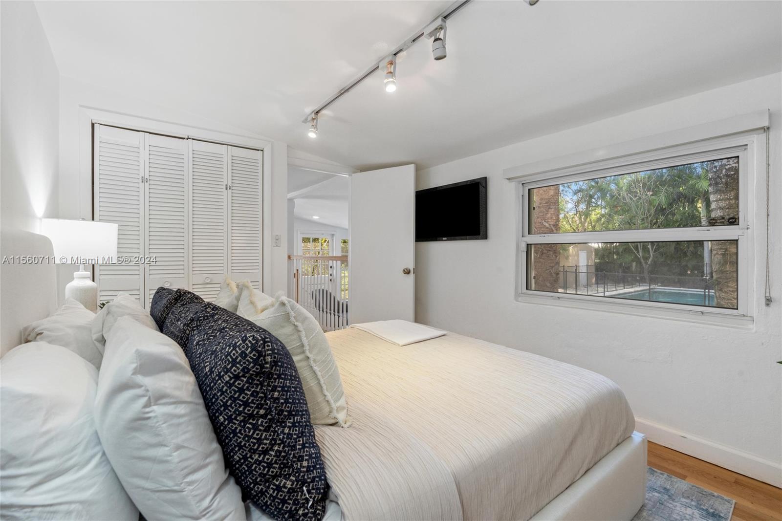 335 Southwest 31st Road Miami, FL 33129 - Photo 12 of 20 a bedroom with a large bed and a flat tv screen on dresser with wooden floor