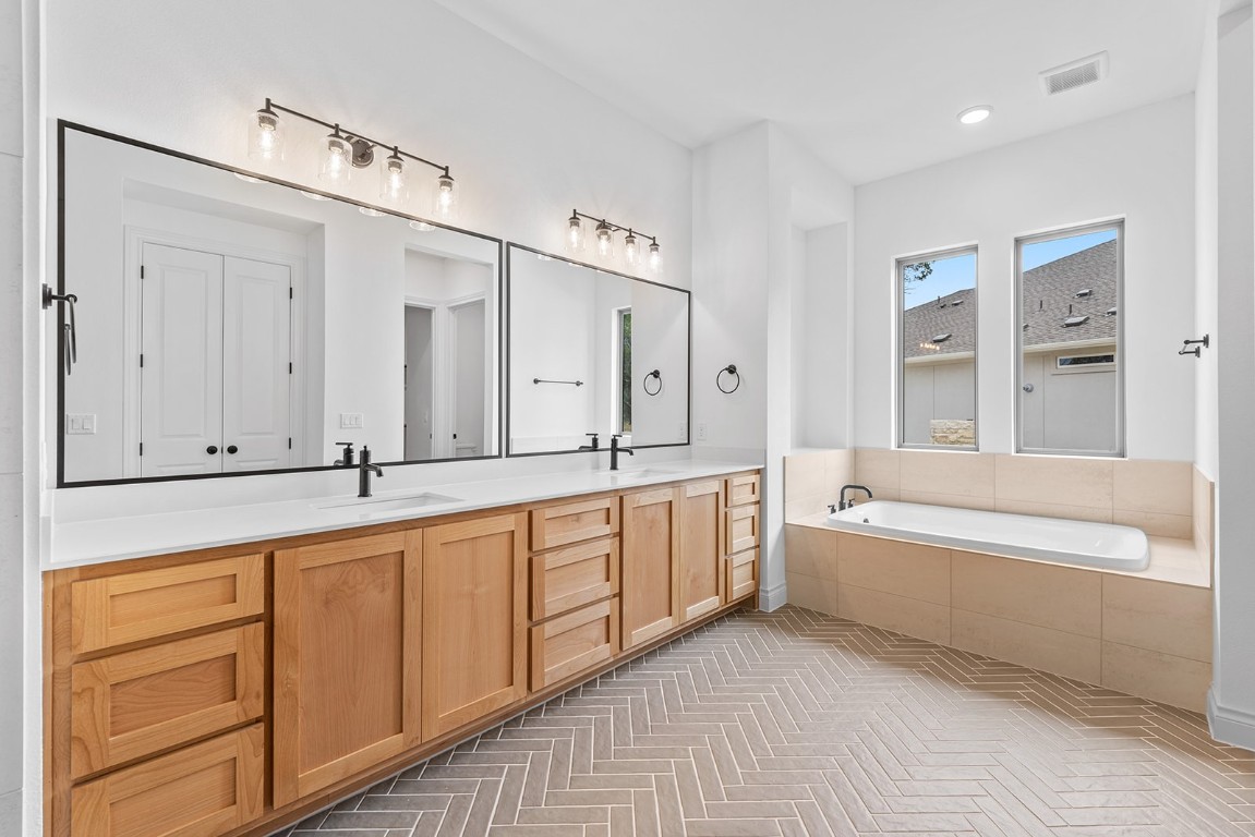 4608 Destination Way Jonestown, TX 78645 - Photo 15 of 29 a spacious bathroom with a tub sink and mirror
