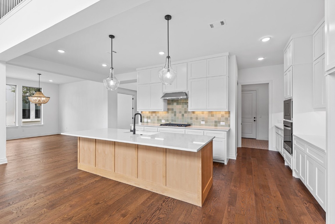 4608 Destination Way Jonestown, TX 78645 - Photo 6 of 29 a large kitchen with stainless steel appliances kitchen island a large island in the center