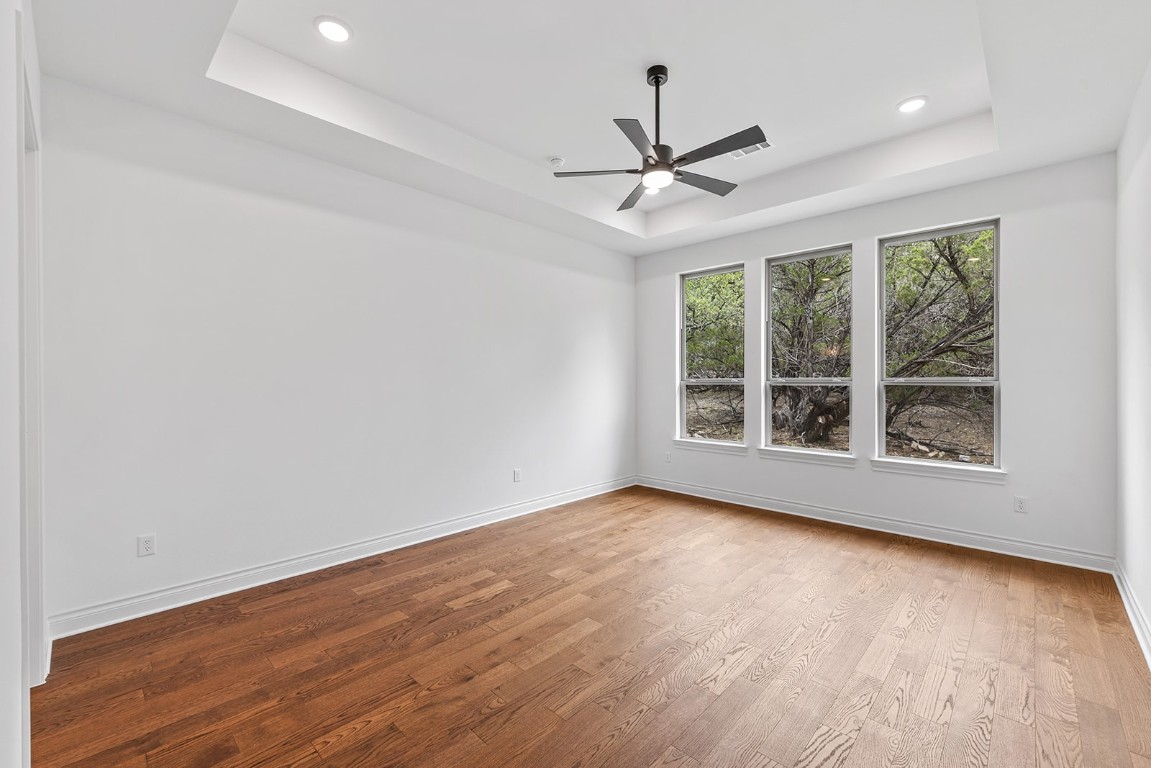 4608 Destination Way Jonestown, TX 78645 - Photo 9 of 29 a view of an empty room with wooden floor and a window