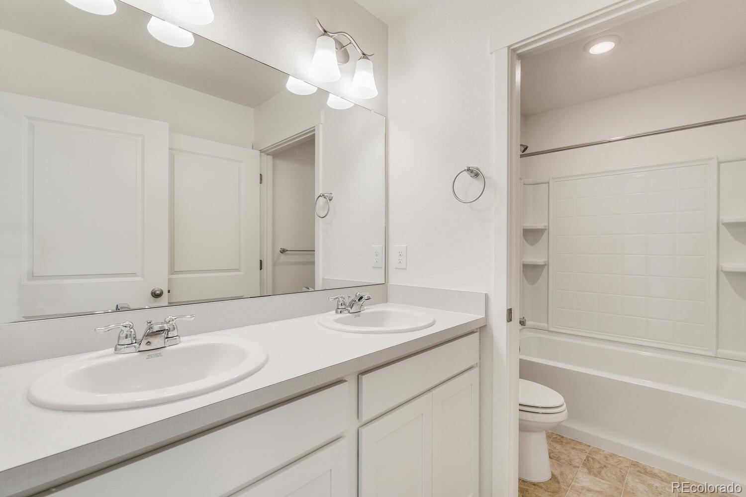 112 66th Avenue Greeley, CO 80634 - Photo 13 of 16 a bathroom with a sink a toilet and shower