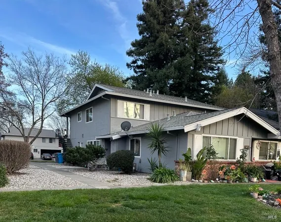 a front view of a house with a garden and plants