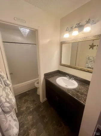 a bathroom with a granite countertop sink and a mirror