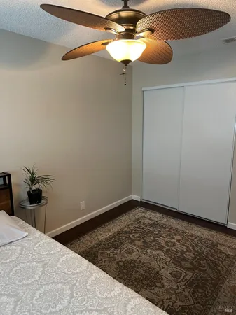 a bedroom with a bed and a chandelier fan