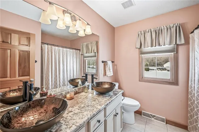a bathroom with a granite countertop sink a toilet and a mirror