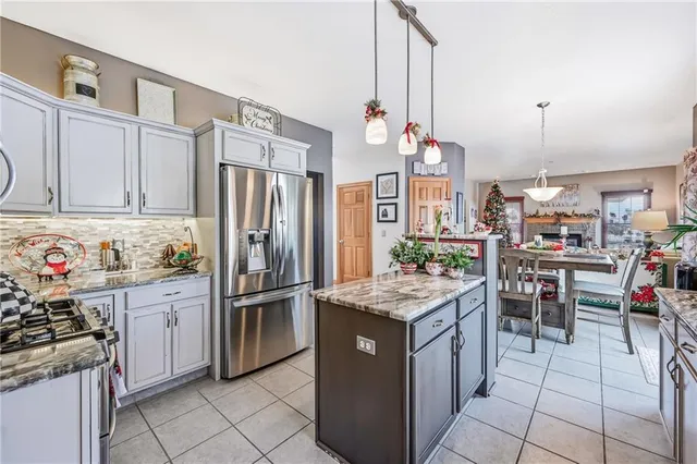 a kitchen with granite countertop stainless steel appliances a stove refrigerator and cabinets
