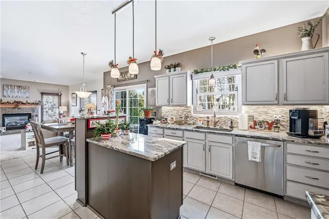 a kitchen with kitchen island granite countertop a sink counter top space appliances and cabinets