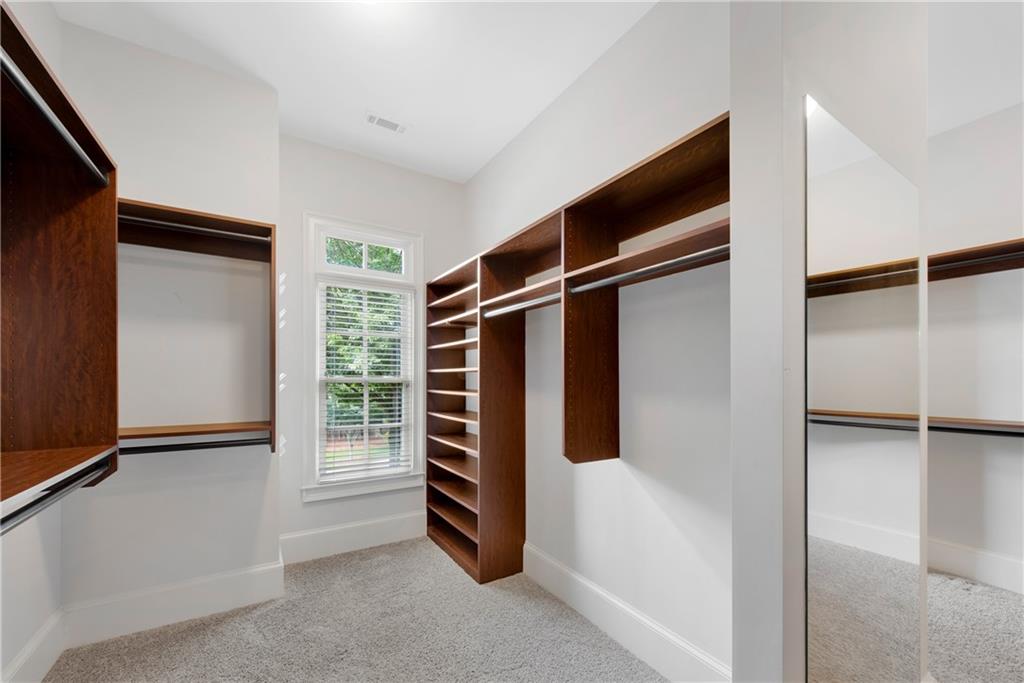 13942 Tree Loft Road Milton, GA 30004 - Photo 41 of 102 a view of walk in closet with clothes and shoes