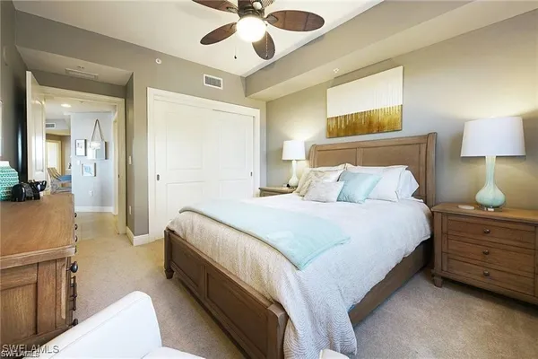 a spacious bedroom with a bed and a chandelier