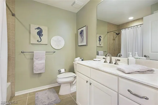 a bathroom with a granite countertop sink mirror vanity and toilet