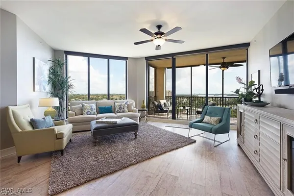 a living room with furniture and floor to ceiling windows