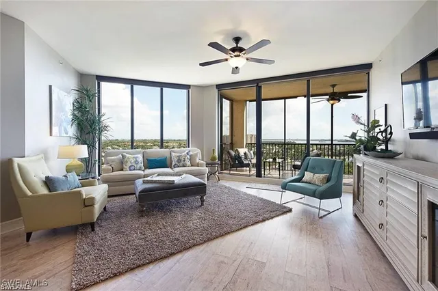 a living room with furniture and floor to ceiling windows