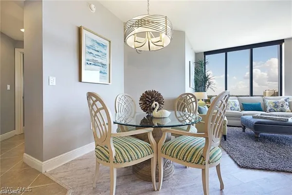 a dining room with furniture and a large window