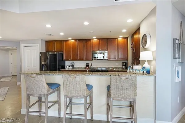 a kitchen with stainless steel appliances granite countertop a refrigerator and microwave