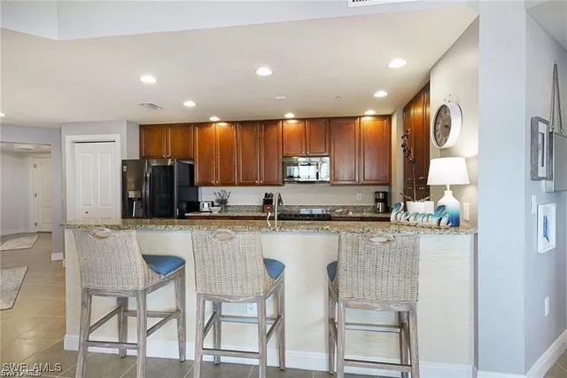 a kitchen with stainless steel appliances granite countertop a refrigerator and microwave
