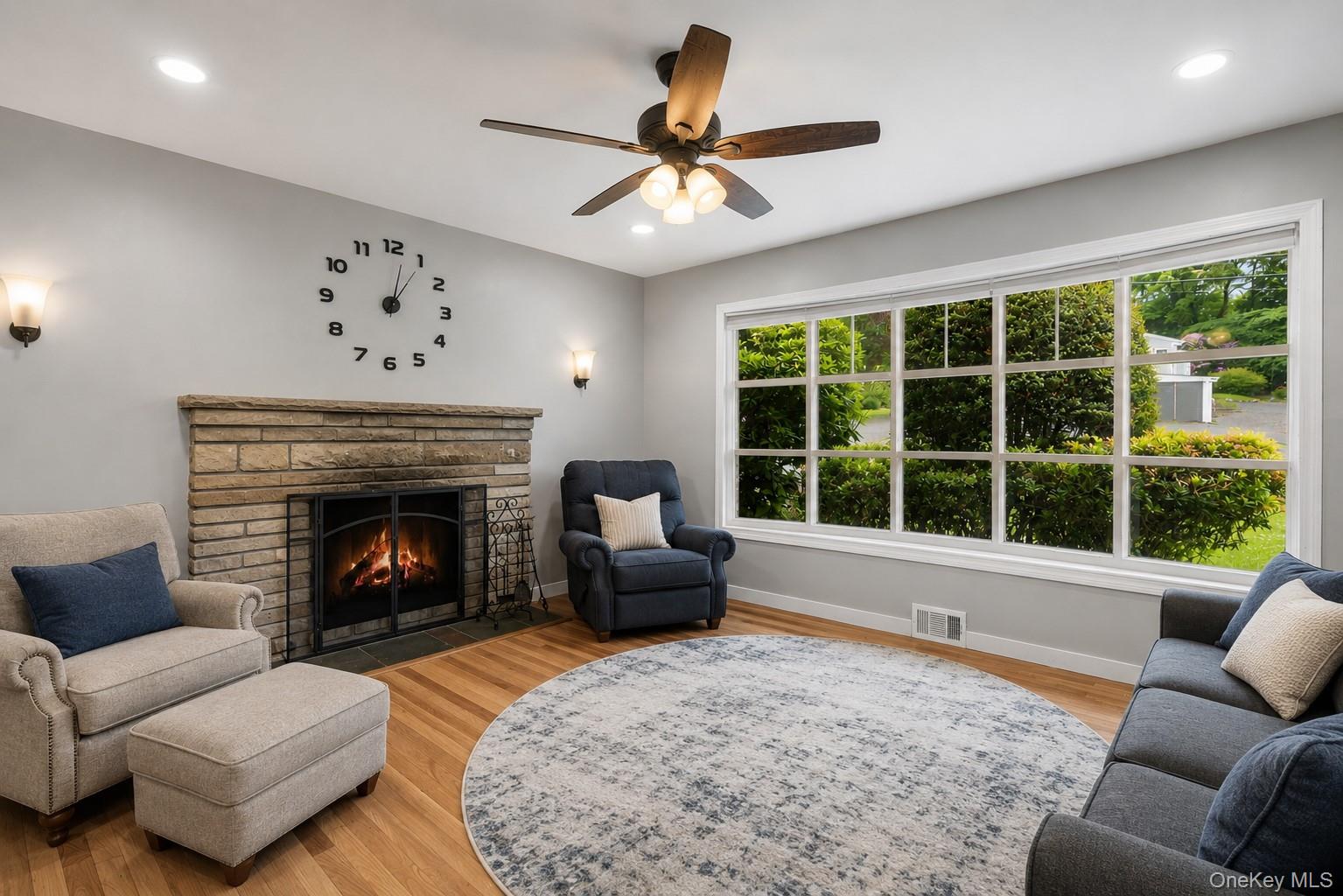 3 Westview Road Spring Valley, NY 10977 - Photo 5 of 21 Living room featuring a stone-clad fireplace, wood-finish flooring, and a ceiling fan